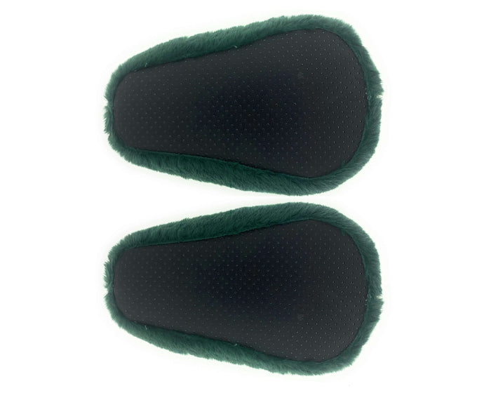 Pair of plush avocado slippers seen from the bottom, showing black fabric soles with non-slip grips, on a white background
