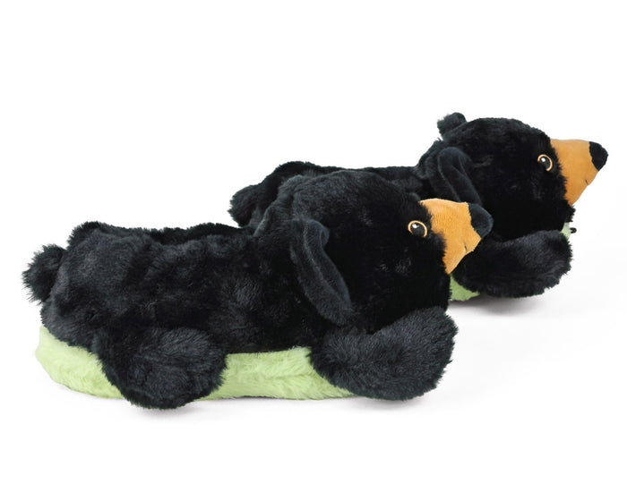 Pair of black bear-shaped slippers with green soles on a white background