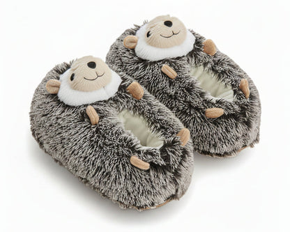 A pair of plush hedgehog slippers with gray and white faux fur, tan paws, and a face on the top, shown on a white background.