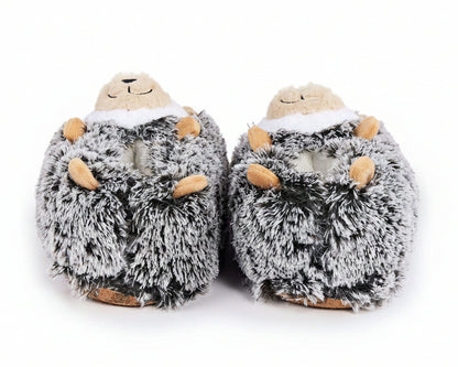 A pair of plush hedgehog slippers in gray and white faux fur with small tan accents on the paws and snout, shown against a plain white background.
