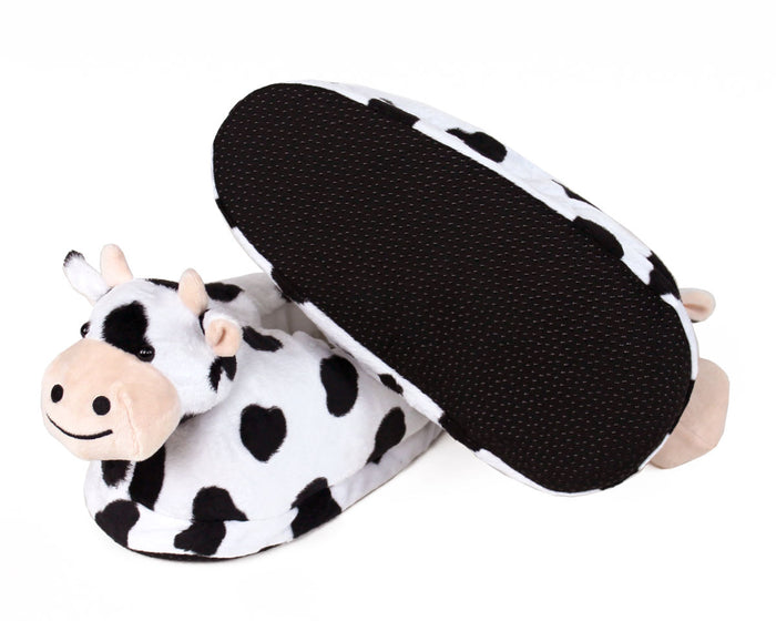 Cow-patterned slippers on a white background, one is turned upside-down to show sole with non-slip grips